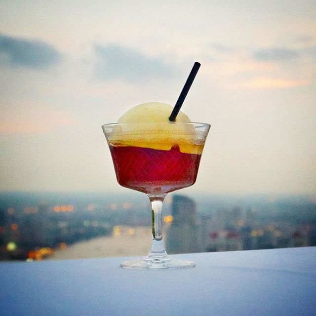 Orange cocktail with city in background