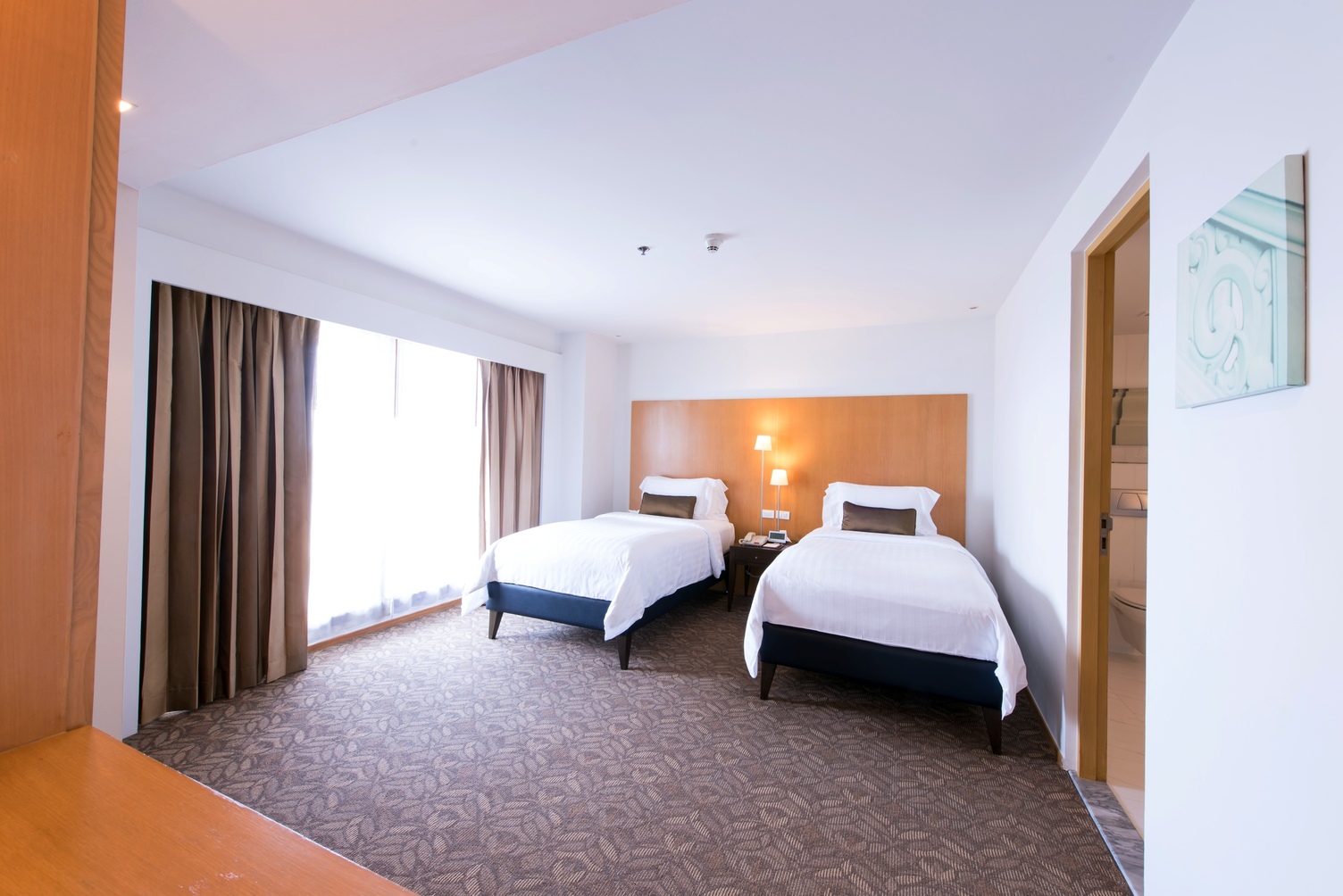two twin beds window on the left brown curtains