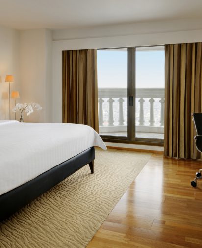 Hotel suite with king size bed, window and office chair