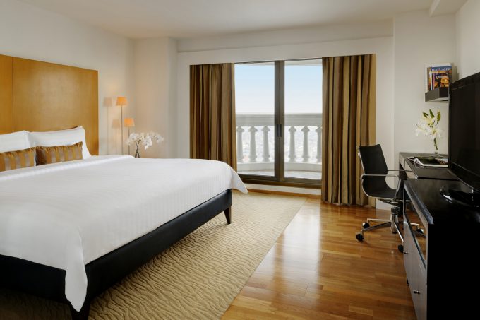 Hotel suite with king size bed, window and office chair