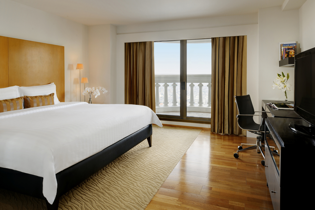 Hotel suite with king size bed, window and office chair